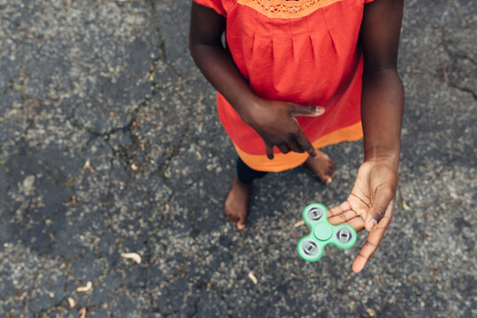 Black girl's hand playing with a fidget spinner