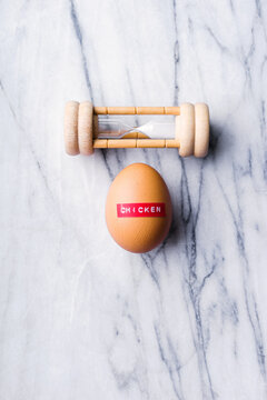 Egg and egg timer on marble background.