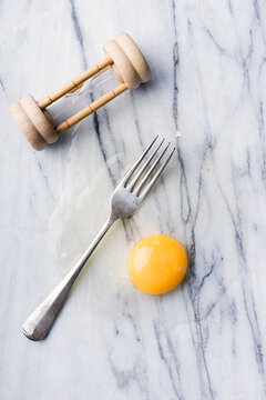 Egg timer,raw egg and fork.