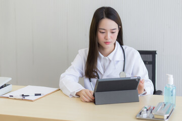  Asian female doctors use tablets to consult information.