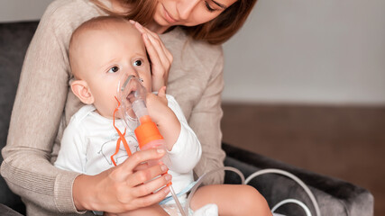 Mother using nebulizer for cute little baby at home. symptom of asthma or pneumonia cause by...