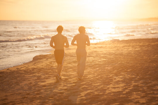 men's couple running at the beach