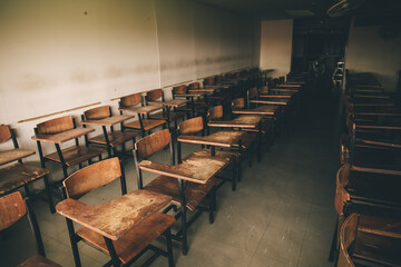 old wooden row lecture chairs in dirty classroom in poor school.study room without student.concept...