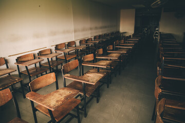 old wooden row lecture chairs in dirty classroom in poor school.study room without student.concept for education in third world ,donate and charity
