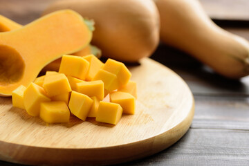 Sliced butternut squash on cutting wooden board for cooking