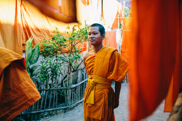Young Buddhist monk walking out of the temple