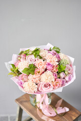Beautiful spring bouquet on wooden table.. Arrangement with various flowers. The concept of a flower shop. A set of photos for a site or catalogue. Work florist.