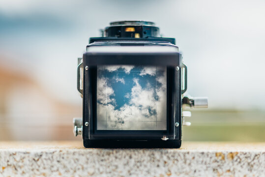 Retro camera focusing on clouds in the sky.