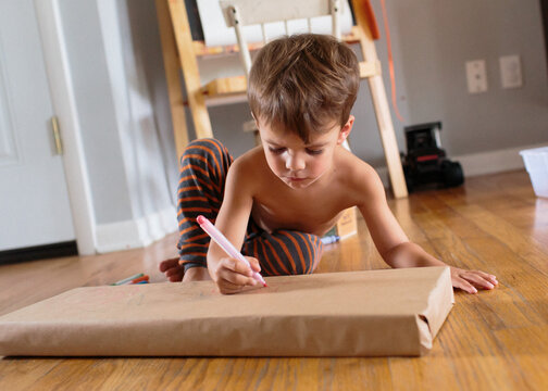 child writes on brown paper package
