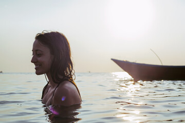 Summertime - woman standing in the ocean