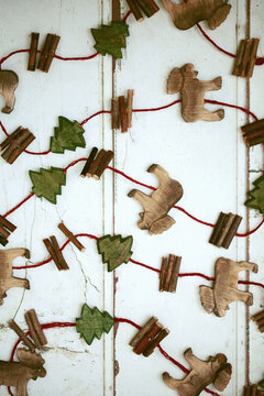 Pattern made with wooden carved reindeers and trees from ornamental handcrafted garland