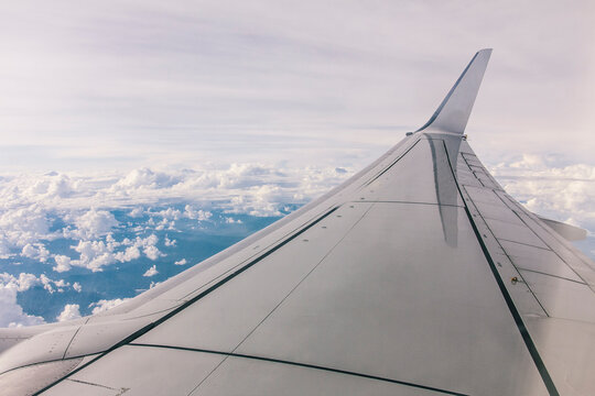 Airplane wing during a flight over a sky with clouds