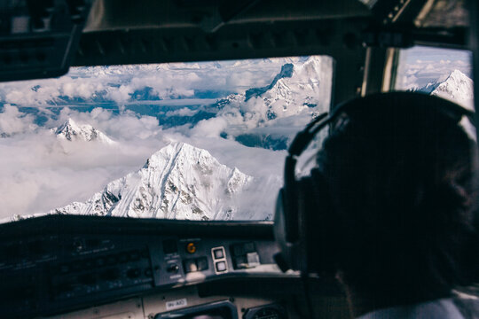 Pilot on airplane cockpit flying over Himalaya mountains