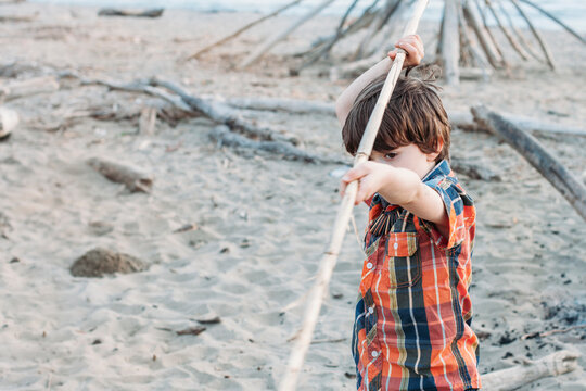 Boy playing with a stick on the beach
