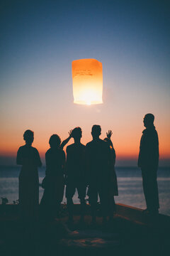 Festival time - friends releasing sky lantern in sunrise