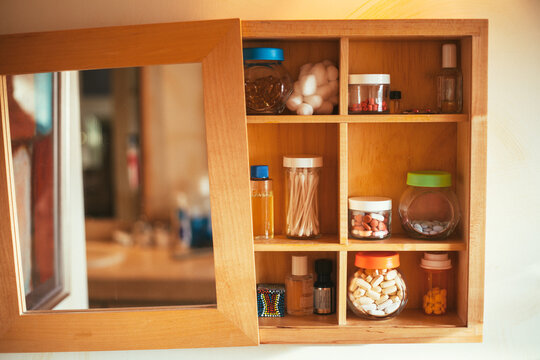 Medicine cabinet filled with vitamins, medication, oils and other bathroom items