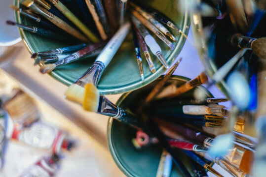 Paintbrushes inside containers in an artist's studio