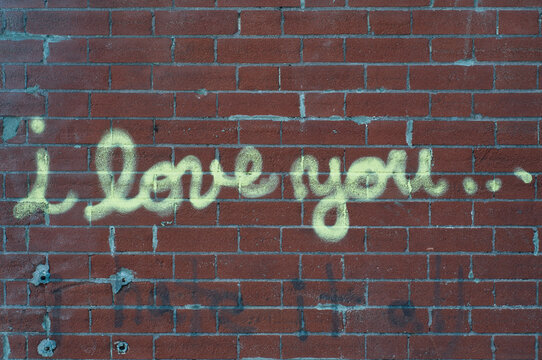 i love you..."" on a brick wall
