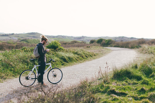 Man standing still with bicycle to set a timer.