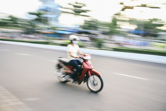 Young woman riding a motorbike - moped. Speed blurred image