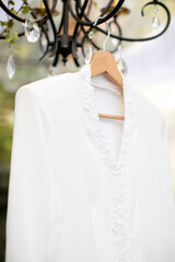 a white wedding dress hanging on the chandelier