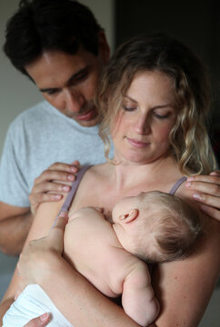 Multiethnic couple cuddling their fair skinned baby