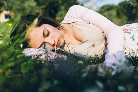 Cute girl resting on a flower meadow