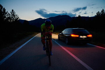 triathlon athlete riding bike at night