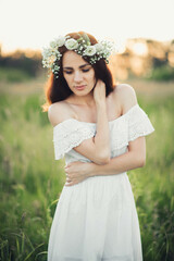 Fototapeta na wymiar attractive Caucasian brunette girl in white dress and with wreath