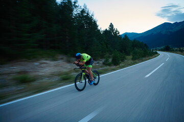 triathlon athlete riding bike at night
