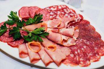 slices of ham and sausage on a plate for a snack