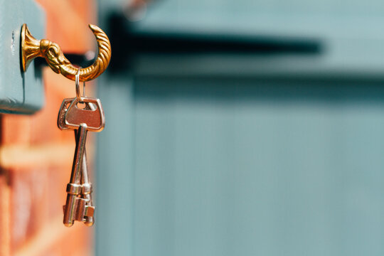 Keys hang on a wall by a blue garden gate