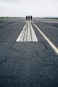 Three women walking on airport runway