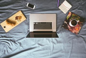 Laptop set for work on bed