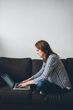 Woman sitting on couch with laptop