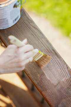 Staining: Woman Brushes On Stain With Wood Grain