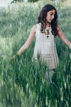 Beautiful girl walking in the middle of a wheat field