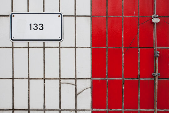 Number plate on white red building tiles