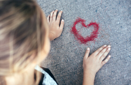 Young girl over a heart she made from a bottleneck brush shrub