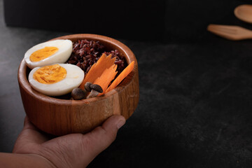 Riceberry Rice with Boiled Egg and Vegetables in a Wooden Bowl