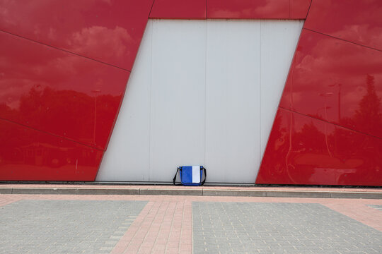 Blue white bag leaning on red white wall
