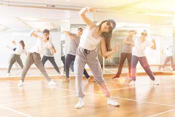 Fototapeta na wymiar Joyous boy and girls dancing hip hop at lesson in the dance class