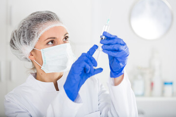 Young female nurse ready to make injection in hospital