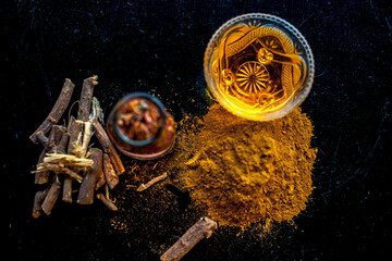 Quick Healing wound paste consisting of natural ayurvedic herbs i.e. Revand chini well mixed with rose water and honey. Shot of revand chini roots, powder, rose water and honey on a wooden surface.;