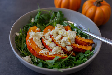 healthy arugula salad with roasted pumpkin and feta cheese