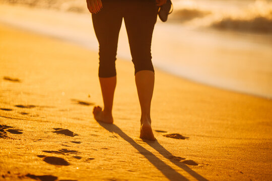 Woman walking by the shore on sunrise