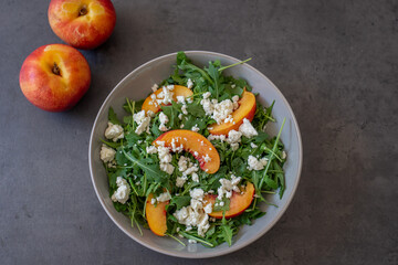 healthy arugula salad with peach and feta cheese
