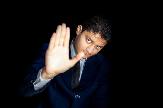 A Tired Man Saying NO TO WORK Isolated On A Black Colored Background Wearing A Blue Colored Suit.