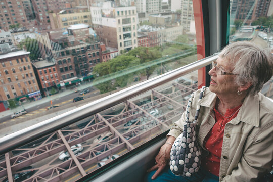 Senior Woman Enjoying View of Manhattan from Above Riding Cable Car Tram
