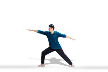 A young enthusiastic teenage boy in sportswear isolated with reflection and doing Yoga stretch.